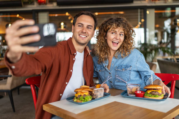 istock Happy couple taking selfie with smart mobile phone at burger pub restaurant 2196924424