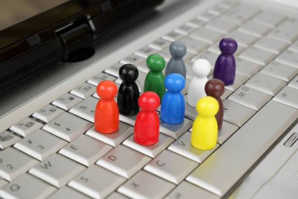 istock Different wooden figures of people on laptop computer keyboard. 2196926531
