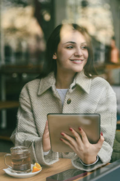 istock Beautiful Female Looking Through Restaurant Window Getting Distracted by Beautiful View While Working 2196927676