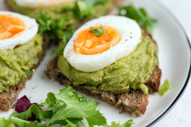 istock Avocado toast with egg and green leaf salad 2196929624