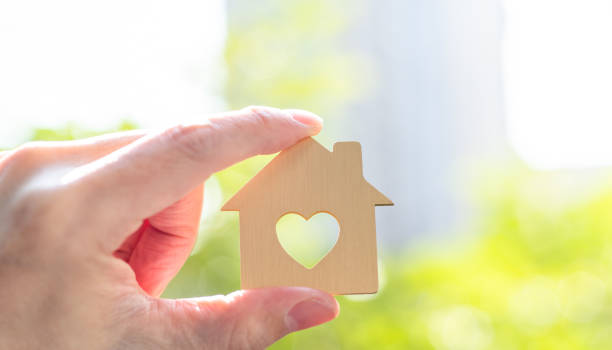 istock Human hand holding model house with a heart shape 2196931363