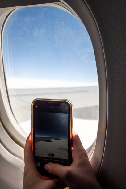 istock Hands Holding Smartphone Capturing Scenic Aerial View Through Airplane Window 2196932688