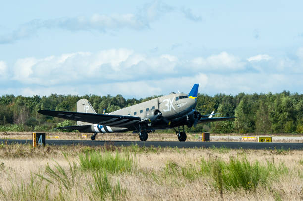 Vintage Douglas DC-3 propellor airplane flying in mid air in a cloudy sky over Zwolle in Overijssel, Netherlands.