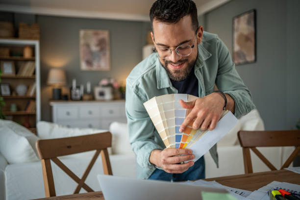 istock Interior designer showing a color palette over a camera in his creative home office 2196936400