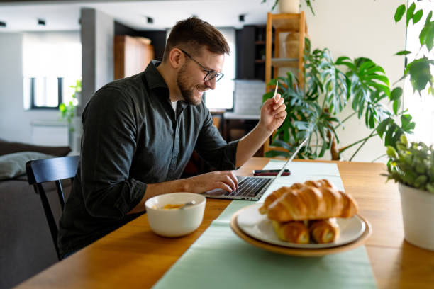 istock Young Man Making Online Purchases While Having Breakfast at Home 2196937245