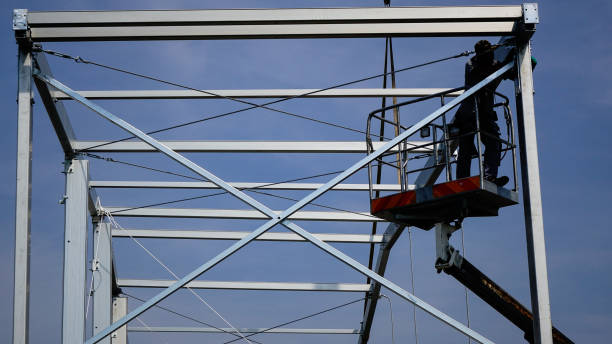 istock Man workers  on a crane performs high-rise work on welding metal structures of new tower at height.Silhouette Photo 2196940501