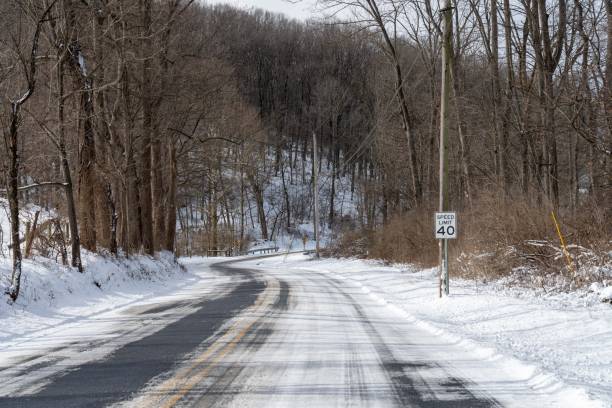 istock Snowy rural road with speed limit sign. 2196940737