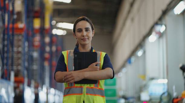 istock Satisfied Hispanic Latin warehouse worker in confident post with  looking away with computer in logistic warehouse. 2196946417