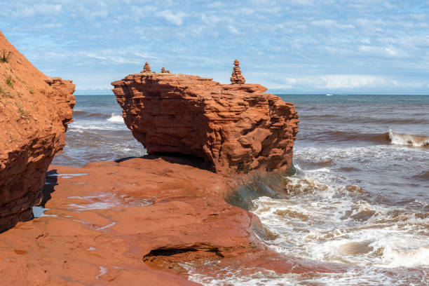 Red rocks and small inukshuks at Thunder Cove Beach on PEI, Canada