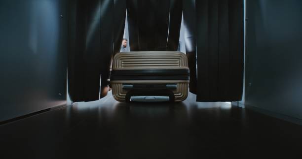 Security Checkpoint in Modern Airport Terminal: Close Up of Suitcase Moving on Conveyor Belt Inside Advanced Metal Detector X-ray Scanner. Luggage Screening Procedure for Boarding Airplane Flight.