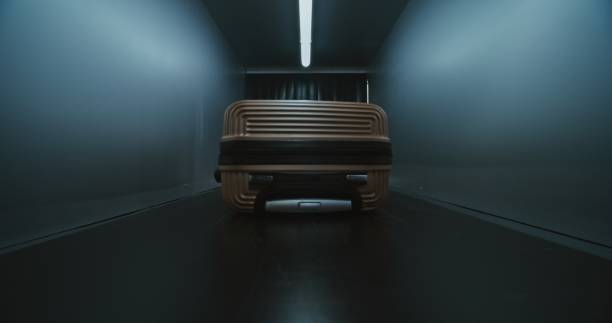 Airport Security Checkpoint: Male Traveler, Passenger Places Baggage on Conveyor Belt for Screening Procedure for Boarding Plane Flight. Close Up of Suitcase Moving Inside the Advanced X-ray Scanner.