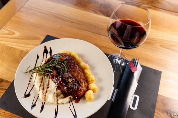 istock Exquisite Plated Crispy Duck Dish with Mashed Potatoes and Artistic Garnish and Red Wine Glass 2196953194