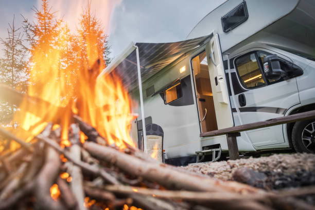 istock Camping by the Fire With an RV in a Tranquil Forest Setting at Dusk 2196953883