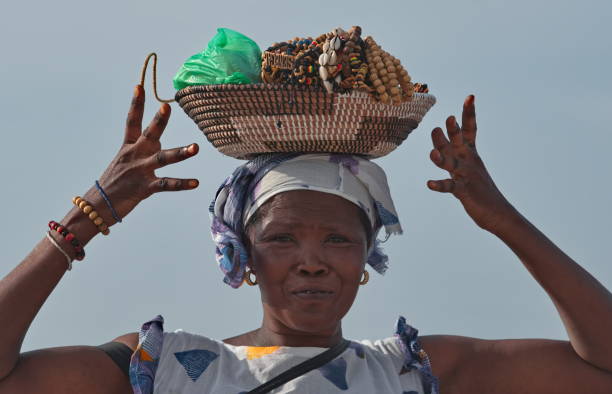 Dakar. Senegal. October 12, 2021. A woman seller from a village on the shore of Pink Lake sells souvenir jewelry, which is on her head in a basket.