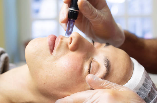 istock Woman is getting a facial treatment with a device. 2196958859