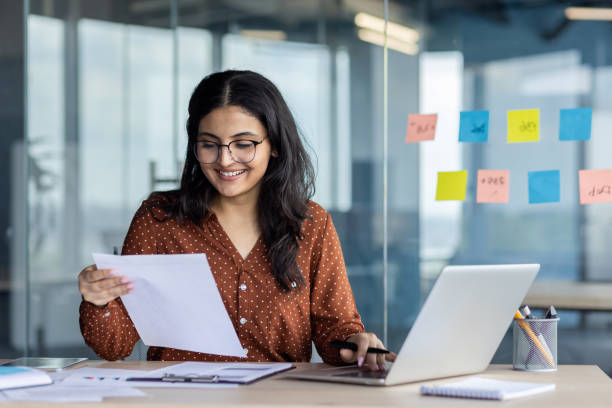 istock Paperwork office work, young successful latina woman working with documents and contracts inside office at workplace. Satisfied woman smiling checking, reports and tax forms 2196963454