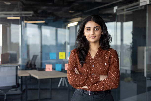 istock Confident businesswoman standing with folded arms in a modern office setting 2196963516