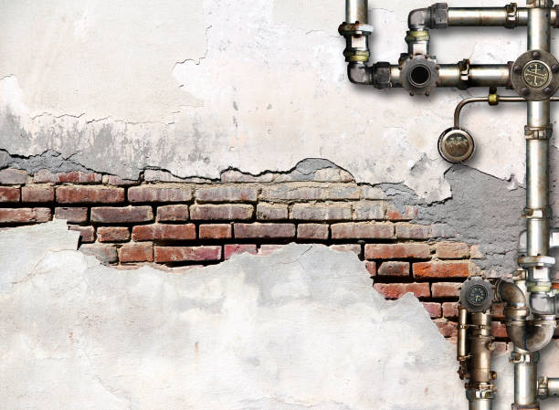 istock Vintage steampunk backdrop with pipes on stucco wall. Open space with brick wall and retro pipelines. Mock-up template. Grunge interior background. Copy space for text 2196963577