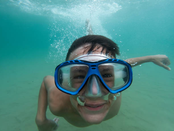 istock Teen boy playing above and underwater 2196963605