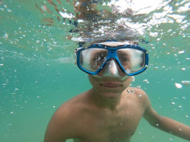 istock Teen boy playing above and underwater 2196963609
