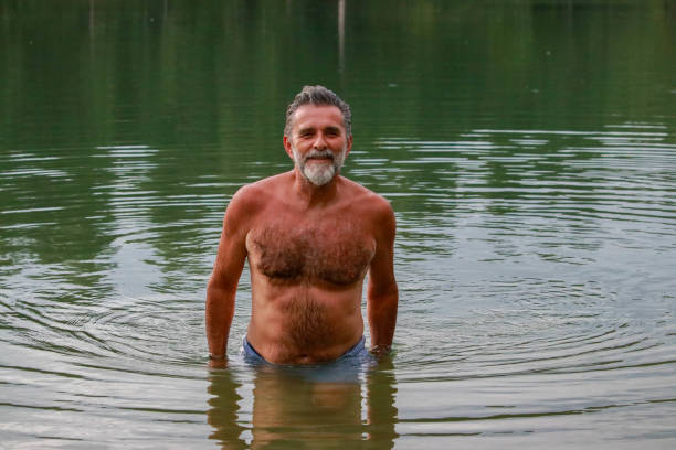 istock Senior bearded man show his body on lake 2196964724