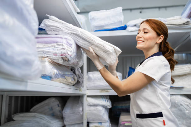 istock Laundry worker stacking hospital linen on the shelf. 2196967599