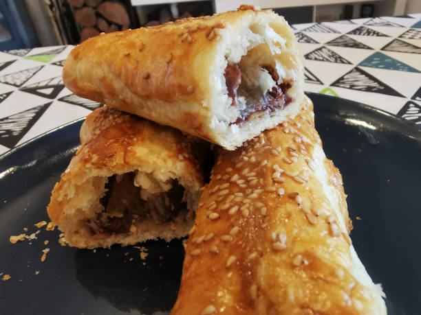 istock Delicious Flaky Sausage Rolls on Blue Plate with Sesame Seeds 2196968950