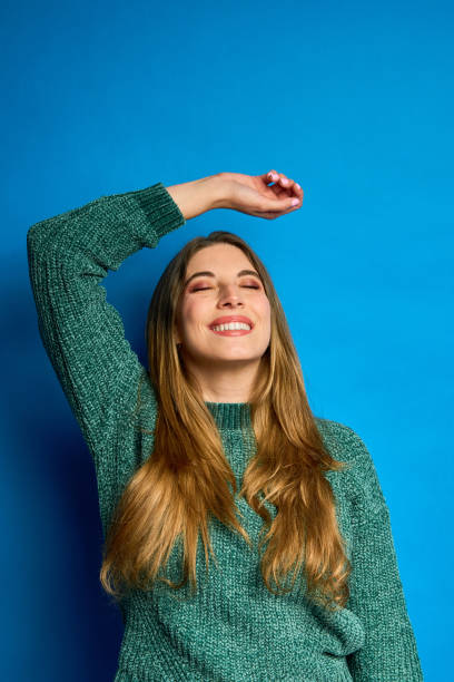 istock Young woman stretching and smiling on blue background 2196969284