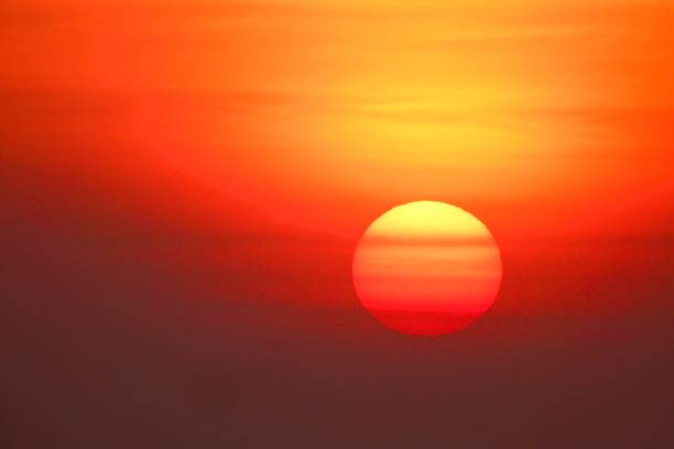 :This stunning high-resolution photo captures the Sun up close, showing intense reds, oranges and yellows. The Sun appears as a large sphere in the dark sky, with the lower part