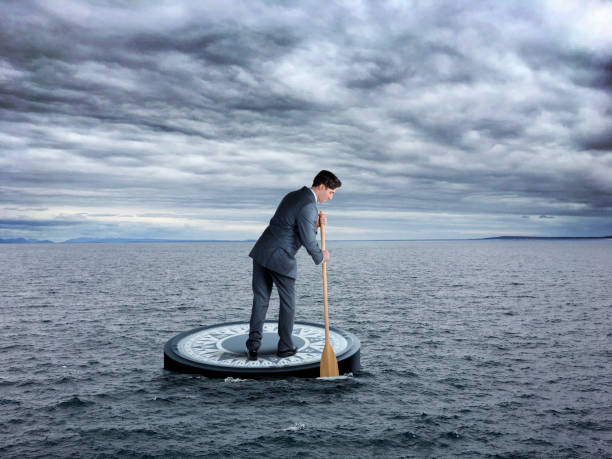istock Man Standing On Compass Paddles His Way To His Destination 2196970551