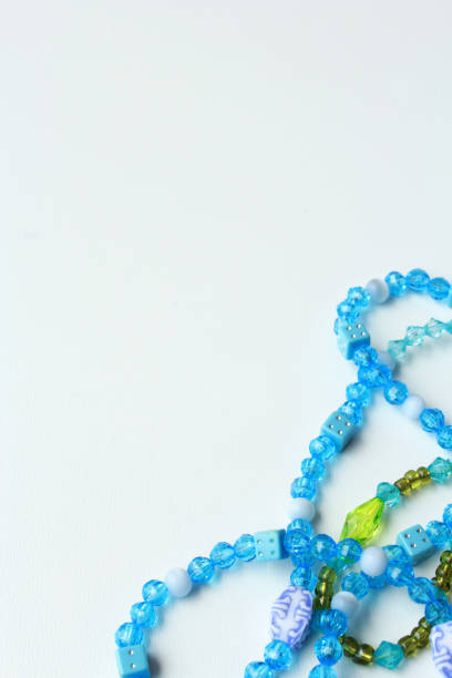 istock Vertical abstract background with copy space, featuring vibrant green and blue acrylic bead necklaces. 2196971535