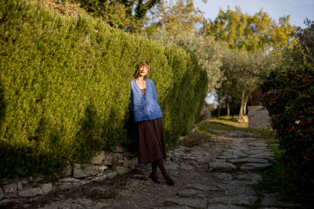 istock Woman Relaxing by Hedge in Sunshine 2196971998