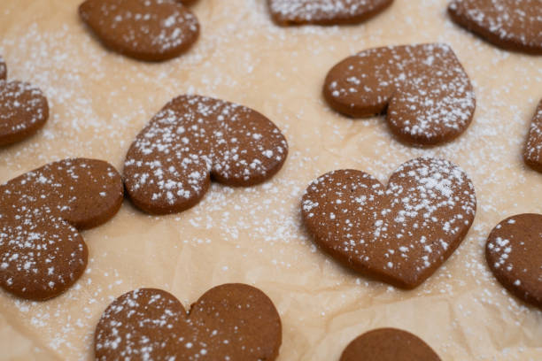 istock Gingerbread heart cookies on parchment paper. Delicious baking 2196976166