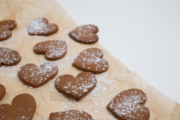 istock Gingerbread heart cookies on parchment paper. Delicious baking 2196976167