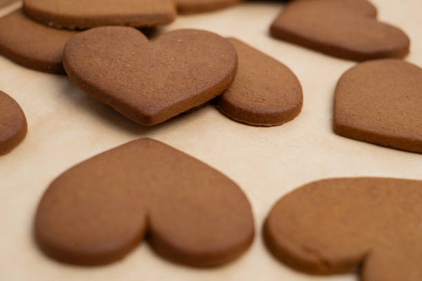 istock Gingerbread heart cookies on parchment paper. Delicious baking 2196976390