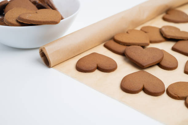 istock Gingerbread heart cookies on parchment paper. Delicious baking 2196976437