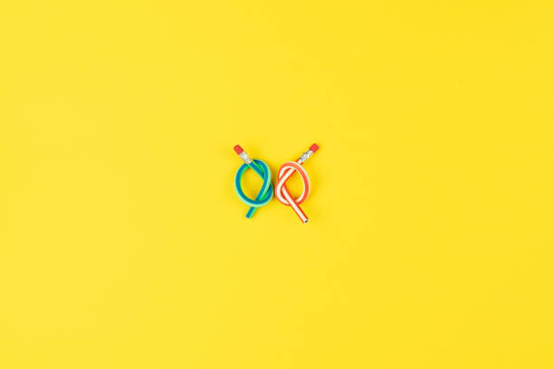 Knotted pencils on yellow background reflect stress in creative projects, stress in daily routines