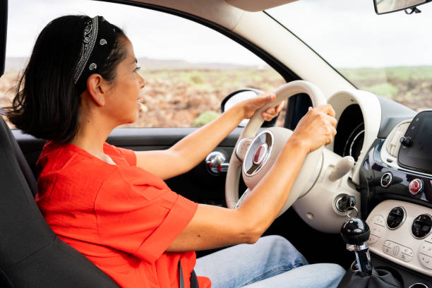 istock Woman driving convertible, sunlight warming face, enjoying open highway, experiencing sense of freedom and adventure 2196977402