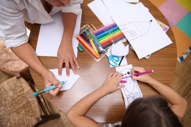istock Children Engaging in Creative Drawing Activity at a Wooden Table 2196978157