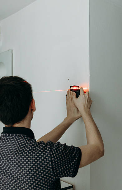 istock A young man uses a laser level on the wall. 2196978875