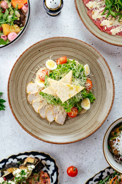 istock Caesar salad with chicken in a plate on the table 2196979220