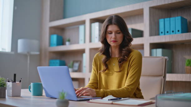 istock Woman online manager working laptop making notes at notebook in office closeup. 2196980981