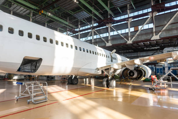 istock White passenger aircraft in the airplane hangar. Jet plane under maintenance 2196982846