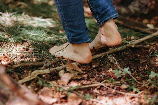 Barefoot walking on a forest trail with leaves, twigs, and greenery in Steffisburg, Canton of Bern, Switzerland