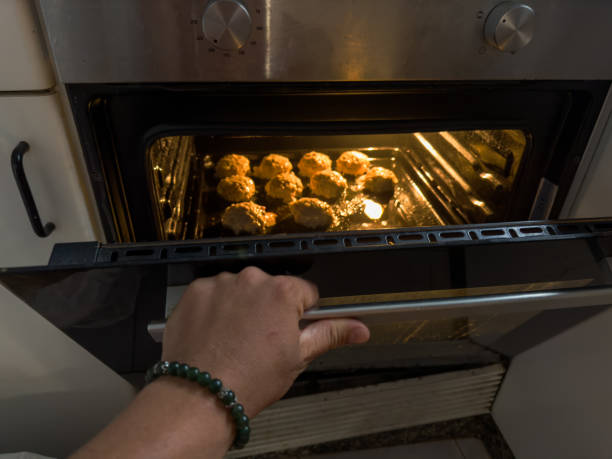 istock Hand Opening Oven with Baking Homemade Buns 2196983401