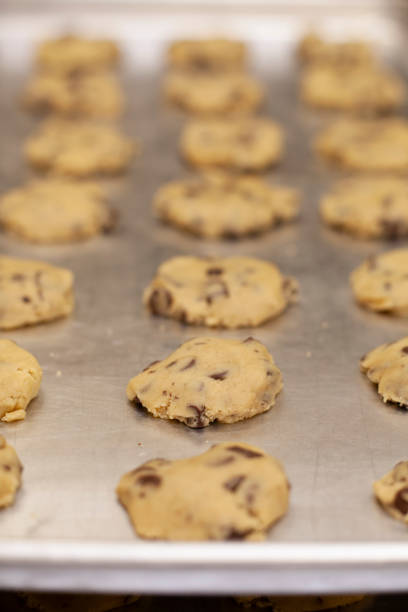 istock Close up on rows of chocolate chip cookie dough on sheet pan 2196985478
