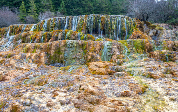 Beautiful vibrantly colored Marvelous Flying Waterfall at Huanglong Scenic and Historic Interest Area in the Minshan Mountains at the edge of the Tibetan Himalayan Plateauin in Songpan County, Sichuan Province, China.