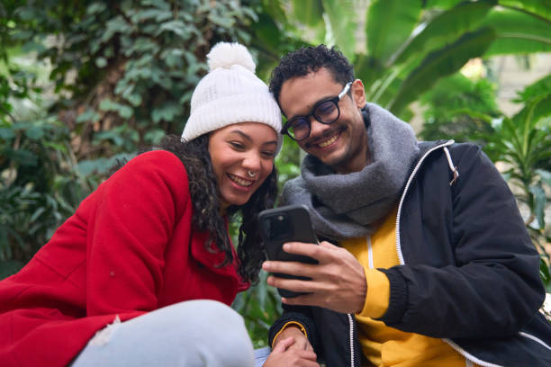 istock Happy couple sharing a special moment using mobile phone in botanical garden 2196987323
