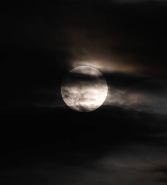 istock Clouds moving across full moon against black night sky. 2196987409