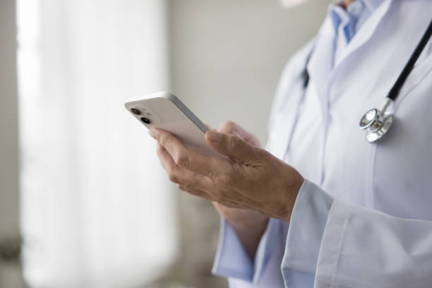 istock Close up unknown female doctor use smart phone at workplace 2196987878